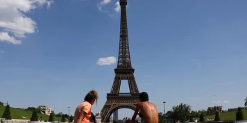Un homme escalade la tour Eiffel et accroche un drapeau américain